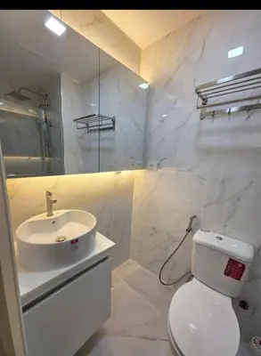 a white bathroom with a sink and a toilet at Jazz Haven Makati in Manila