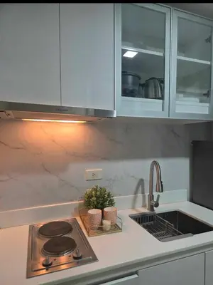 a kitchen counter with a stove and a sink at Jazz Haven Makati in Manila