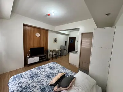 a bedroom with a bed and a television in it at Mels Place at Tulip Garden Condominium Southwoods in Biñan