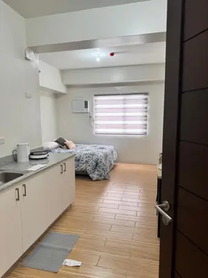 a room with a bed and a kitchen with a counter at Mels Place at Tulip Garden Condominium Southwoods in Biñan