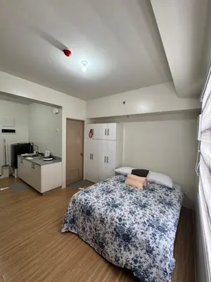a bedroom with a bed and a sink in it at Mels Place at Tulip Garden Condominium Southwoods in Biñan