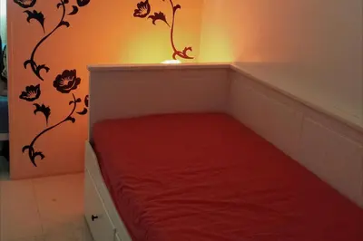 a small room with a bed with a red blanket at My Cozy Little Crib - Sea Residence - Tower C in Manila