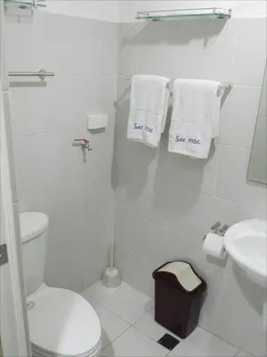 a bathroom with a toilet and a sink and towels at My Cozy Little Crib - Sea Residence - Tower C in Manila