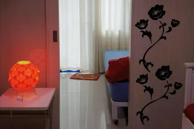 a bathroom with a wall with flowers and a lamp at My Cozy Little Crib - Sea Residence - Tower C in Manila