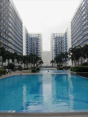 a large swimming pool in a city with tall buildings at My Cozy Little Crib - Sea Residence - Tower C in Manila