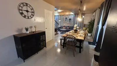 a living room with a table and a clock on the wall at The Grand Escape - Suntrust Verona, Silang Cavite in Silang