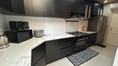 a kitchen with black cabinets and a stove top oven at The Grand Escape - Suntrust Verona, Silang Cavite in Silang