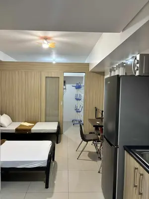 a room with two beds and a kitchen with a refrigerator at 3 single beds transient room mall of asia pasay in Manila