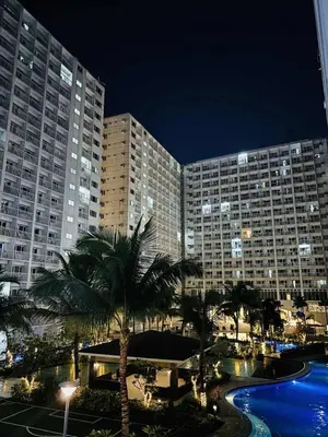 a large building with palm trees in front of it at 3 single beds transient room mall of asia pasay in Manila