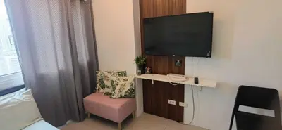 a hotel room with a tv and a chair and a desk at OYO 1172 MVM Transient House in Manila