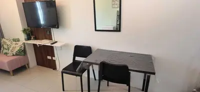 a dining room with a table and chairs and a mirror at OYO 1172 MVM Transient House in Manila