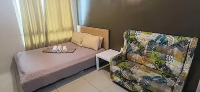 a small bedroom with a bed and a chair at OYO 1172 MVM Transient House in Manila