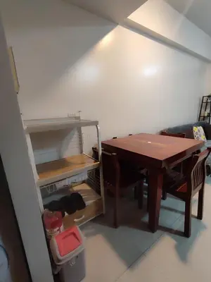a room with a table and some chairs and a shelf at Kmad's Condotel in Manila