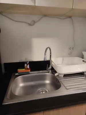 a kitchen counter with a sink in a kitchen at Kmad's Condotel in Manila