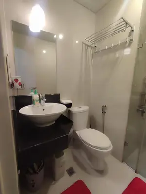 a bathroom with a sink and a toilet and a mirror at Kmad's Condotel in Manila