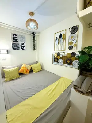 a large bed in a room with yellow pillows at Twins Nest - CASA VICENTE Cozy 2-Bedroom Loft Condo Mandaluyong in Manila