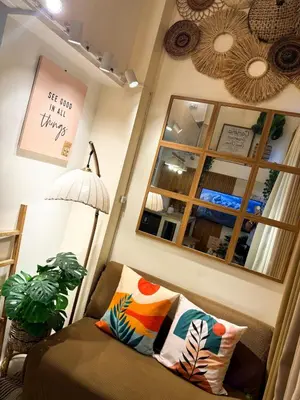 a living room with a chair and a mirror at Twins Nest - CASA VICENTE Cozy 2-Bedroom Loft Condo Mandaluyong in Manila