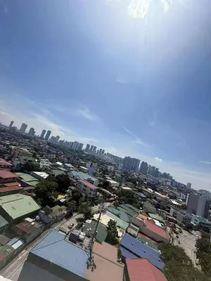 an overhead view of a city with buildings and the sun at Twins Nest - CASA VICENTE Cozy 2-Bedroom Loft Condo Mandaluyong in Manila