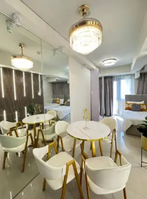 two tables and chairs in a room with a bedroom at Sweet Escape at S Residences in Manila
