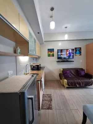 a kitchen and a living room with a couch at Eastwood Legrand3 Studio Type condo in Manila