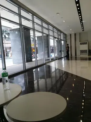 a lobby with tables and a person standing in a building at Eastwood Legrand3 Studio Type condo in Manila