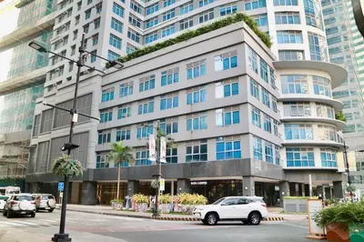 a white car parked in front of a large building at Eastwood Legrand3 Studio Type condo in Manila