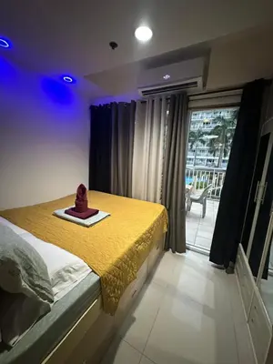 a bedroom with a bed with a hat on it at Wheng Place at Shell Residences MOA in Manila