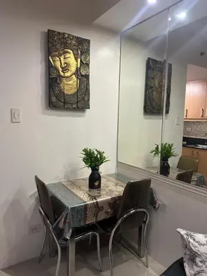 a dining room with a table with chairs andartifacts at Wheng Place at Shell Residences MOA in Manila