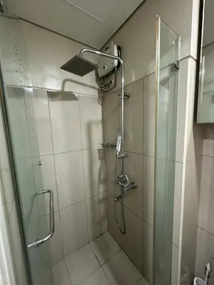 a bathroom with a shower with a glass door at Wheng Place at Shell Residences MOA in Manila