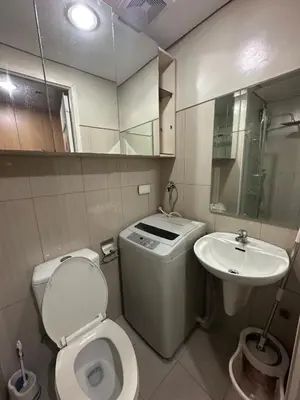 a small bathroom with a toilet and a sink at Wheng Place at Shell Residences MOA in Manila