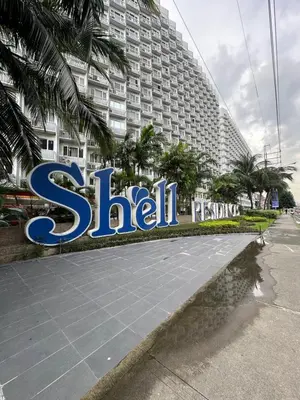 a large sign in front of a large building at Wheng Place at Shell Residences MOA in Manila