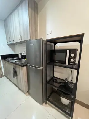 a kitchen with a stainless steel refrigerator and a sink at Good Luck House at S RESIDENCES in Manila