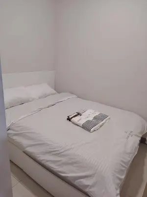 a white bed with a book on top of it at Good Luck House at S RESIDENCES in Manila