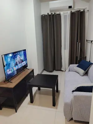 a living room with a couch and a table with a tv at Good Luck House at S RESIDENCES in Manila