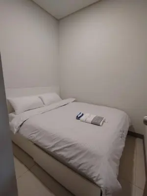 a white bed with a book on top of it at Good Luck House at S RESIDENCES in Manila