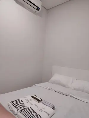 a white bed with two towels on top of it at Good Luck House at S RESIDENCES in Manila