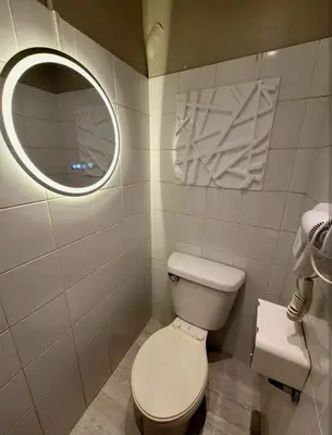 a bathroom with a toilet and a mirror at Amazing 1 5BR unit Connected to Eastwood Mall in Manila