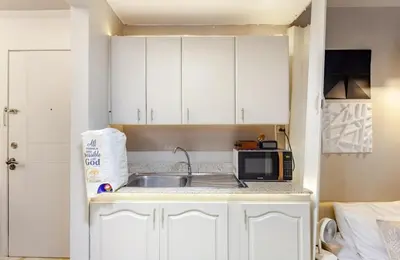 a kitchen with a sink and a microwave at Amazing 1 5BR unit Connected to Eastwood Mall in Manila