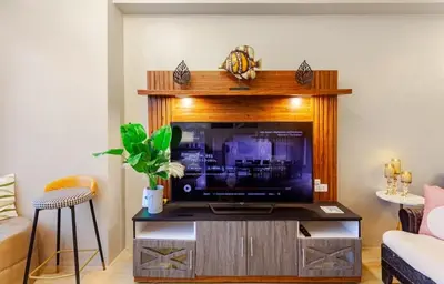 a living room with a tv on a entertainment center at Amazing 1 5BR unit Connected to Eastwood Mall in Manila