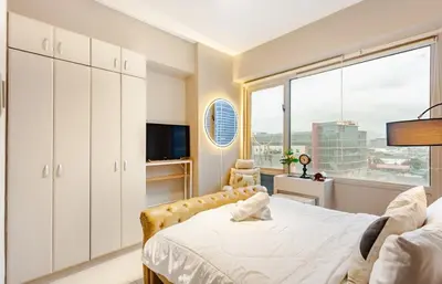 a bedroom with a bed and a large window at Amazing 1 5BR unit Connected to Eastwood Mall in Manila