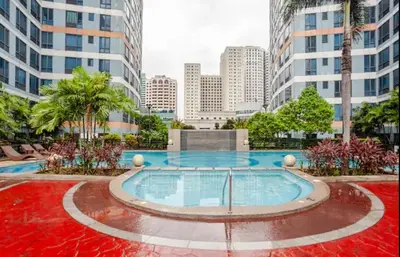 a pool in the middle of a city with tall buildings at Stunning Suite 10 Steps from Eastwood Mall in Manila