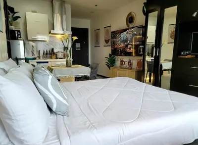 a large white bed with pillows in a room at Incredible Makati Studio Unit w Stunning view & 65 TV in Manila