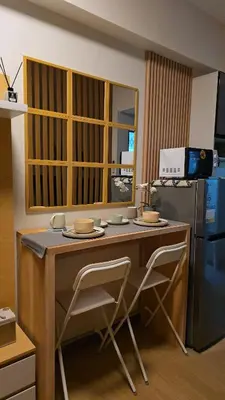a kitchen with a desk with two chairs and a refrigerator at The Beacon Haven in Trece Martires