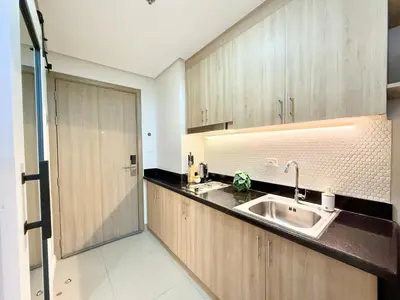 a kitchen with a sink and wooden cabinets at ClaySky Staycation at Shore 2 Residences Tower 2 near Mall of Asia- Hotel Set Up in Amenity and Pool Level with Netflix, HBO Max & Youtube Premium in Manila