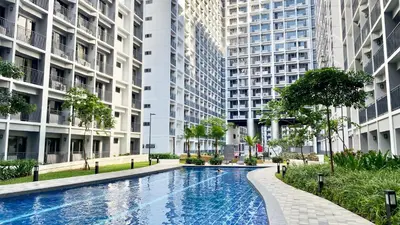 a swimming pool in the middle of two tall buildings at ClaySky Staycation at Shore 2 Residences Tower 2 near Mall of Asia- Hotel Set Up in Amenity and Pool Level with Netflix, HBO Max & Youtube Premium in Manila