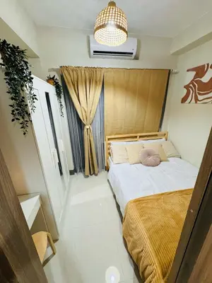 a bedroom with a bed and a chandelier at Newly-furnished 1BR with Balcony near MRT Mandaluyong in Manila