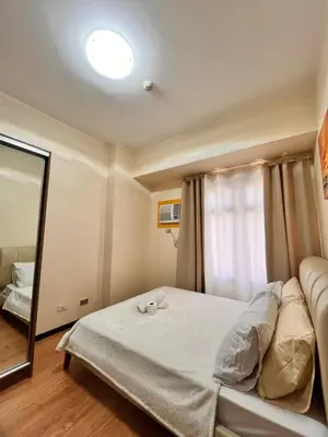 a bedroom with a bed and a mirror at Radiance Manila Bay Bayview Comfort with Pool & Pet-Friendly in Manila