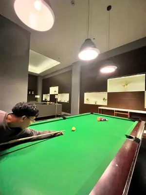 a man in a pool room with a green pool table at Radiance Manila Bay Bayview Comfort with Pool & Pet-Friendly in Manila