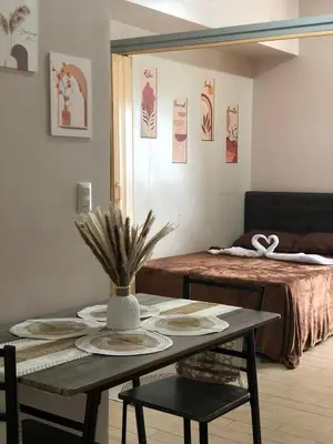 a room with a table with plates and a bed at Estancias De Sofielo in Manila