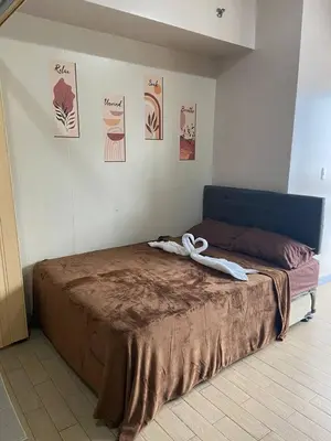 a bed in a room with posters on the wall at Estancias De Sofielo in Manila
